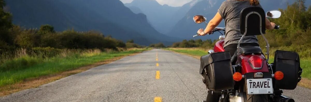 une femme conduisant une moto, sur une autoroute